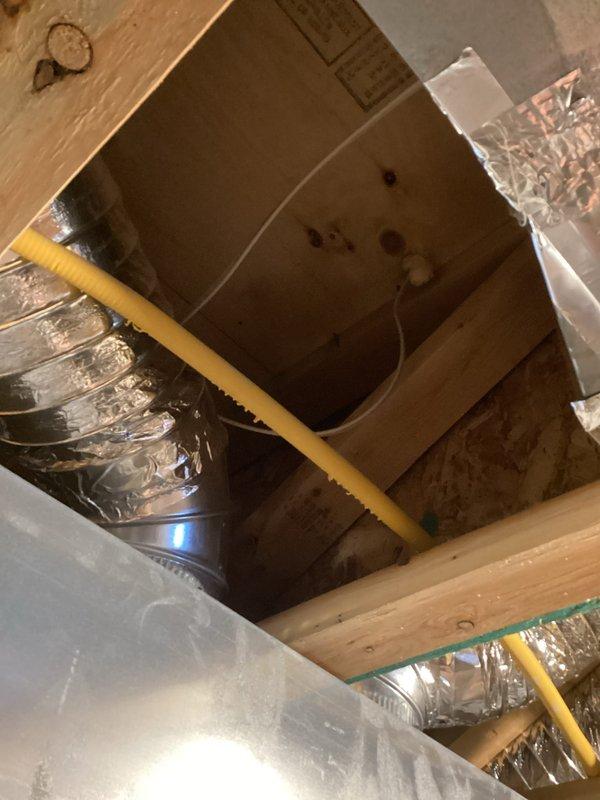 Relocated thermostat from its original position where direct sunlight was causing inaccurate temperature readings. Installed new wiring through ceiling joists in unfinished basement area and mounted the thermostat in a more suitable location away from solar exposure to ensure proper HVAC system operation and temperature control.