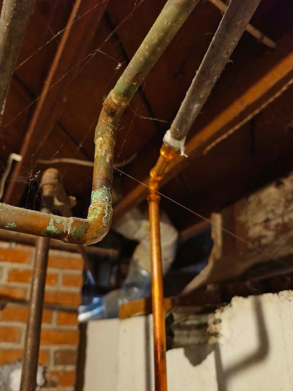 Responded to service call for a pinhole leak in an aging copper supply pipe emitting a water mist in basement/utility area. Located the source of the leak in a 1/2" water line showing significant oxidation and corrosion. Successfully repaired the compromised section of pipe, eliminating the active leak.