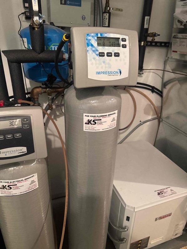 Installed iron filter system with digital Impression control panel, connected to existing water treatment equipment and pressure tank. System was properly configured with appropriate copper piping and electrical connections to address iron content in water supply.