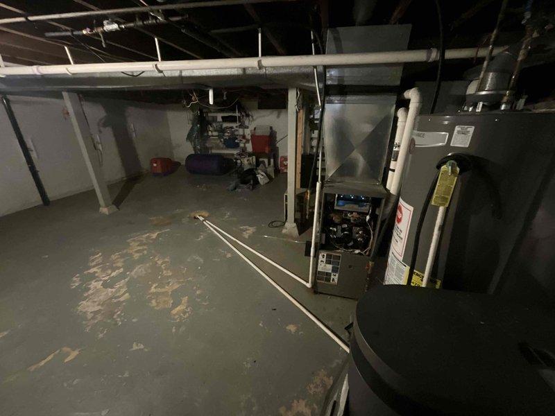 Performed comprehensive duct cleaning consultation in customer's unfinished basement, examining HVAC system with open furnace panel for inspection. Assessed existing ductwork configuration running through exposed ceiling joists, documenting current system condition with photographic evidence for service recommendation.