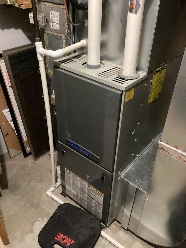 Performed scheduled tune-up service on air handler system. Inspected furnace with PVC exhaust ventilation and condensate lines, verifying all connections showed proper purple primer application at joints. System was operational with no issues detected during comprehensive evaluation.
