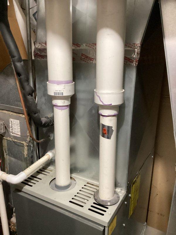 Performed scheduled tune-up service on air handler system. Inspected furnace with PVC exhaust ventilation and condensate lines, verifying all connections showed proper purple primer application at joints. System was operational with no issues detected during comprehensive evaluation.