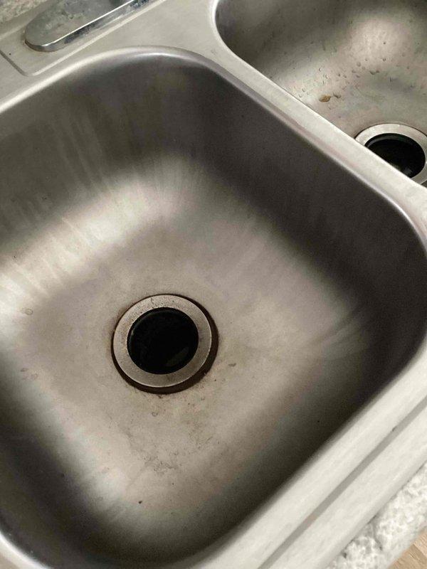 Responded to service call for kitchen and laundry drainage issues. Discovered improperly installed S-trap under kitchen sink with no venting for either kitchen or laundry drains, causing cross-drainage between kitchen sink and washer/dryer connection. Identified potential blockage in main drain line and recommended professional drain inspection and camera service to diagnose complete extent of issue.