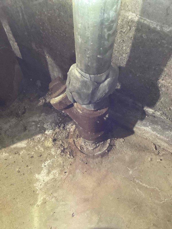 Responded to service call for a leaking pipe in the mechanical room. Discovered a hole in a 1 1/2" galvanized kitchen drain line showing significant corrosion at the connection point. Applied temporary patch to control the leak; will return with a 1 1/2" Fernco coupling to properly repair the damaged section.