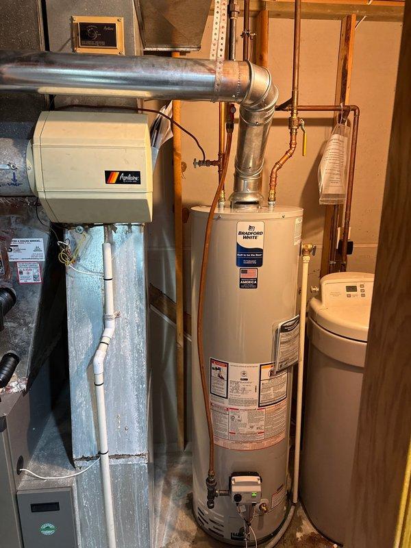 Replaced 40-gallon Bradford White atmospheric natural gas water heater and repaired humidifier system by installing new solenoid valve as per sold proposal. Additionally, replaced leaking copper supply line connected to the Aprilaire humidifier unit mounted adjacent to the furnace system.