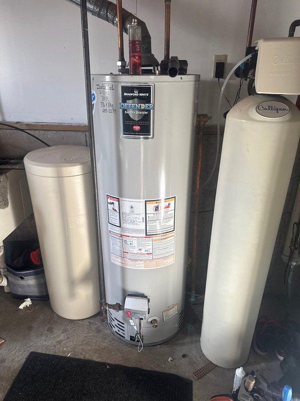 Responded to service call for no hot water. Diagnosed Bradford White water heater with ignition failure. Inspection revealed internal tank leak with visible cracking. Due to safety concerns and presence of small child, recommended complete unit replacement. Provided customer with replacement options.