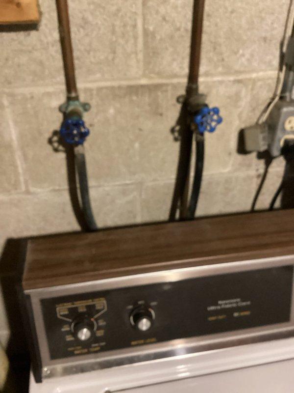 Responded to service call for water supply issues at washing machine. Diagnosed and repaired frozen/stuck intake valves by loosening laundry hose bibs with wrench and repeatedly cycling valves to restore proper operation. Identified significant corrosion and multiple breaks in cast iron drain standpipe requiring replacement; documented condition with photos and noted customer should be informed about necessary drainage system repairs.