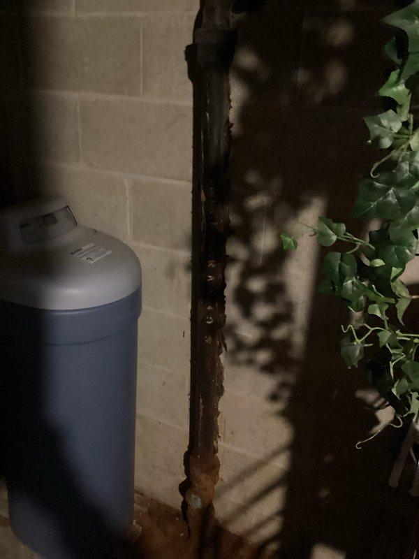 Responded to service call for water supply issues at washing machine. Diagnosed and repaired frozen/stuck intake valves by loosening laundry hose bibs with wrench and repeatedly cycling valves to restore proper operation. Identified significant corrosion and multiple breaks in cast iron drain standpipe requiring replacement; documented condition with photos and noted customer should be informed about necessary drainage system repairs.