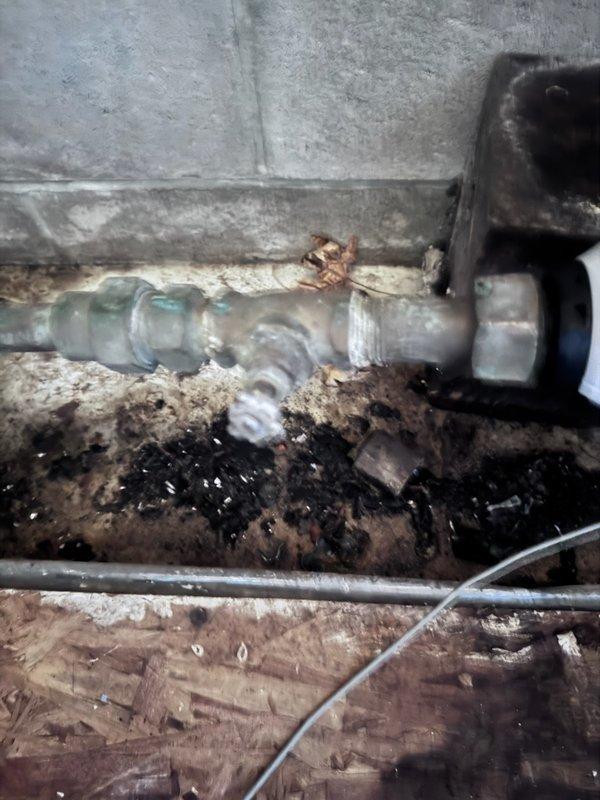 Responded to emergency call for burst pipe in customer's basement. Upon inspection, identified leak at plumbing connection against concrete wall with significant water damage and debris buildup around the fitting. Customer had water shut off by city prior to arrival. Service appointment was rescheduled as customer was informed of technician's delayed arrival.
