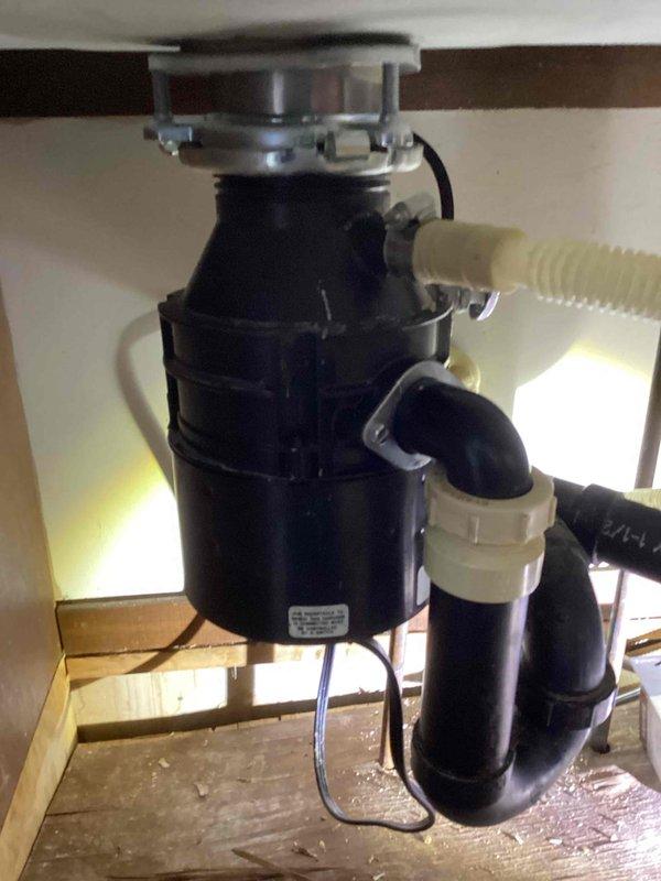 Responded to service call for leak between kitchen sink and garbage disposal. Inspection revealed disposal flange was loose and missing a screw, causing leakage. Installed new disposal flange and reset the disposal unit, successfully resolving the issue and restoring proper functionality.