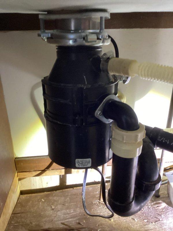 Responded to service call for leak between kitchen sink and garbage disposal. Inspection revealed disposal flange was loose and missing a screw, causing leakage. Installed new disposal flange and reset the disposal unit, successfully resolving the issue and restoring proper functionality.