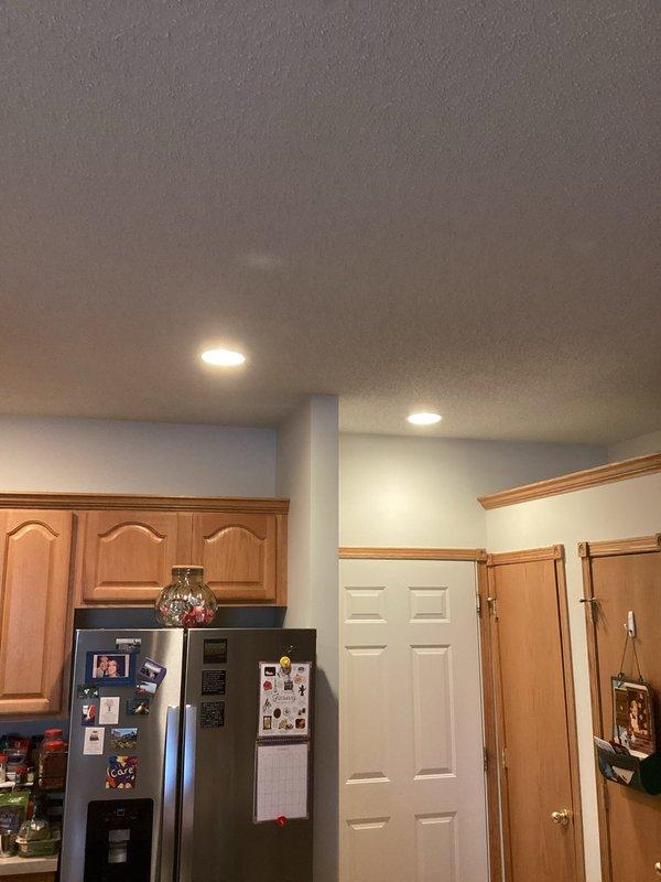 Responded to service call regarding flickering light fixture above stove. Diagnosed issue as combination of loose bulbs and overheating due to high wattage bulbs in recessed can lights. Replaced with appropriate lower wattage bulbs to prevent future overheating and ensure proper fixture operation.