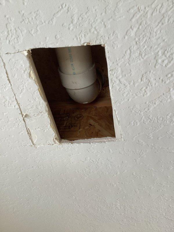 Responded to callback regarding persistent small toilet leak after previous wax ring replacement. Inspection revealed cracked PVC toilet flange that was lifting from floor when toilet was secured. Installed new toilet repair flange and reglued the 90-degree fitting, instructing customer to allow 2 hours for proper adhesive curing before use.