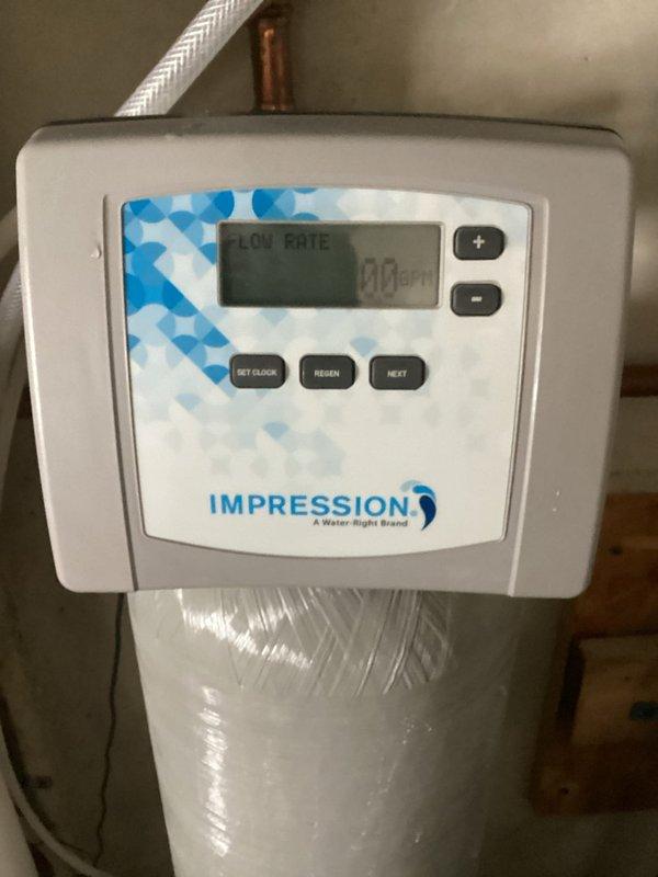 Diagnosed water softener system failure showing symptoms of standing water in brine tank and failure to drain during regeneration cycle. Inspected Impression (Water Right brand) control panel and internal components of brine tank, noting the float mechanism and vertical PVC pipe assembly. Determined need for follow-up service with senior technicians to fully resolve the drainage issue affecting regeneration functionality.