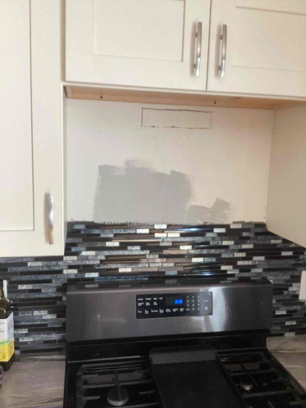 Arrived to perform gas-to-electric stove conversion. Assessed installation requirements and provided estimate for running new electrical wiring through attic and fishing down exterior wall to power the stainless steel range. Existing kitchen has decorative tile backsplash and white cabinetry that will remain intact during conversion.