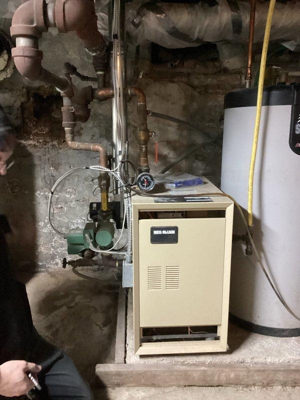 Responded to no heat complaint in home with 11 radiators. Diagnosed low water pressure and air in system causing 2 radiators (master bedroom and bath) to malfunction. Serviced Weil-McLain boiler by draining and refilling system, then bled radiators to restore proper heating function throughout the home.