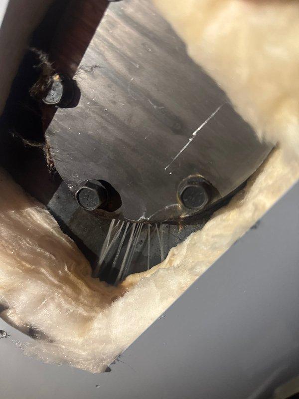 Responded to service call for water heater leak. Upon inspection, discovered factory-installed clean-out was improperly tightened, causing water to escape. Resolved issue by properly tightening the clean-out component, eliminating the leak.