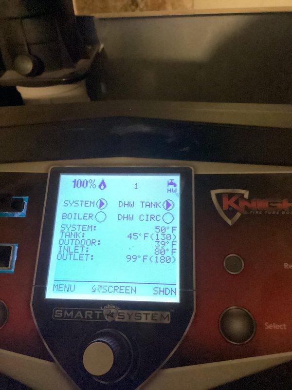 Responded to service call for heating system malfunction. Diagnosed faulty ignitor and successfully installed replacement component. System tested after repair with all parameters functioning normally - control panel showing proper flame operation (100%) and appropriate temperature readings across the system (inlet: 39°F, outlet: 99°F).