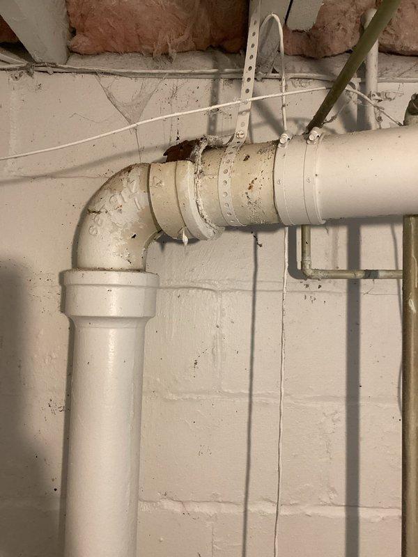 Repaired damaged plumbing system by removing broken cast iron drain pipe with visible hole in 90-degree fitting and converting to PVC. Additional services included shimming and tightening loose toilet on main floor and replacing leaking kitchen faucet on second floor.