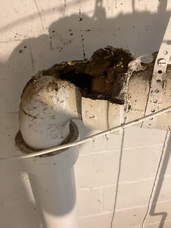 Repaired damaged plumbing system by removing broken cast iron drain pipe with visible hole in 90-degree fitting and converting to PVC. Additional services included shimming and tightening loose toilet on main floor and replacing leaking kitchen faucet on second floor.