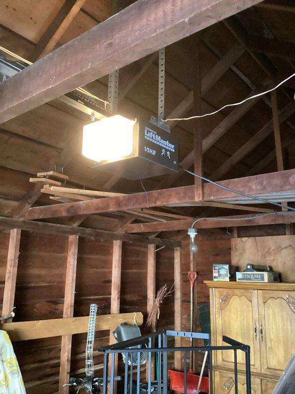 Installed new outlet in garage for automatic door opener by extending wiring from existing switch box to opener location. Replaced exposed doorbell transformer and secured proper connections, eliminating safety hazard of exposed wires. Rewired transfer to ensure proper electrical function and code compliance.