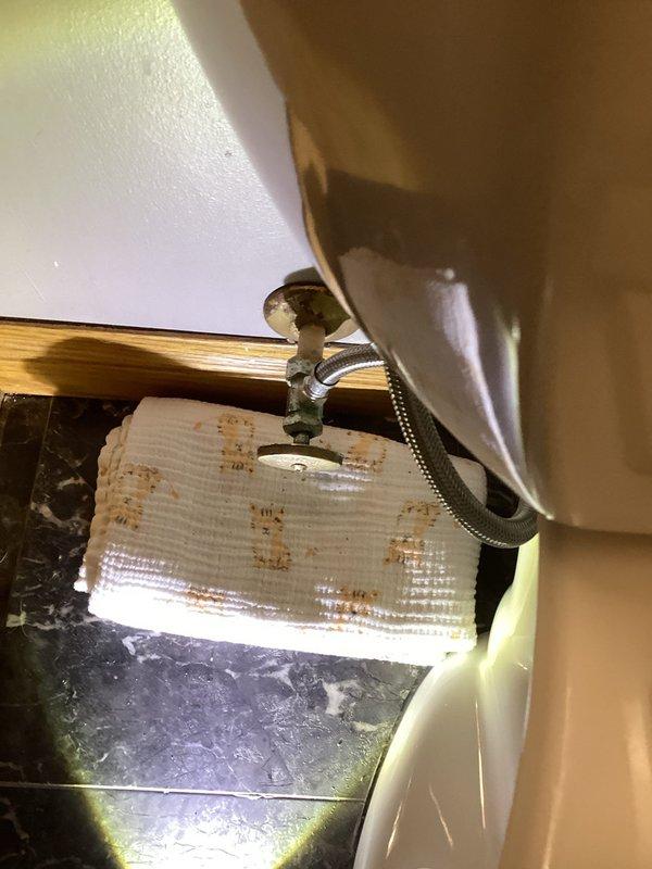 Responded to service call for toilet leak in basement bathroom. Upon inspection, identified loose packing nut on angle stop valve causing water seepage. Tightened packing nut to proper specification and performed multiple flush tests to verify repair. No leaks observed after repair completion.