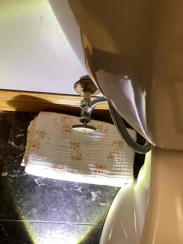 Responded to service call for toilet leak in basement bathroom. Upon inspection, identified loose packing nut on angle stop valve causing water seepage. Tightened packing nut to proper specification and performed multiple flush tests to verify repair. No leaks observed after repair completion.