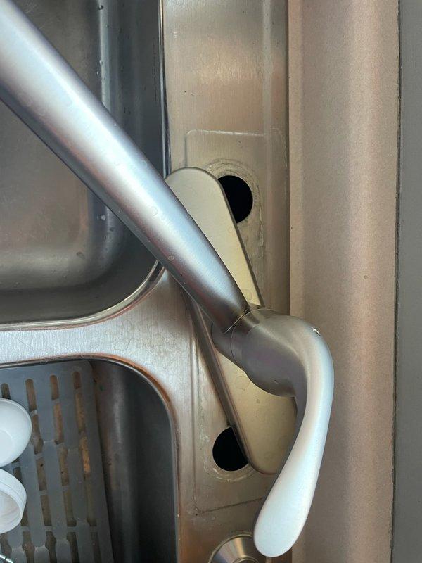 Returned to service a previously installed kitchen faucet that had become loose. Diagnosed issue as a loose plastic retaining nut beneath the sink. Tightened the nut securely, restoring proper functionality and stability to the faucet assembly.