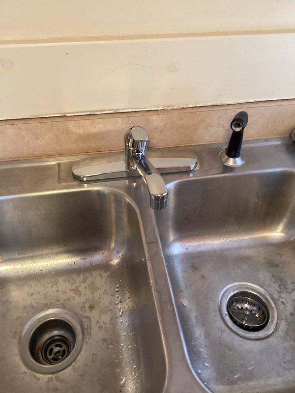 Replaced section of deteriorated 4" cast iron drain line in basement with new 4" PVC pipe and 90-degree fitting to address hole in main line. Installed new single-handle kitchen faucet on second floor, replacing the existing unit. Reset rocking toilet on main floor with new wax seal and toilet bolts to secure properly.