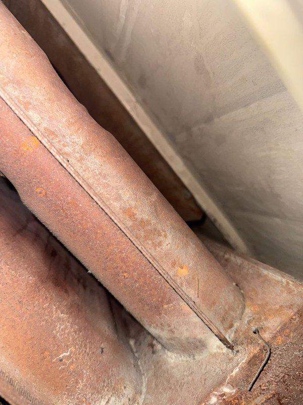 Responded to no-heat call for 1982 Trane furnace making noise on shutdown. Inspection revealed severely corroded heat exchanger with visible cracks and burned molex connection for blower motor. Unit was red-tagged due to safety hazards and recommended preventative maintenance for replacement.
