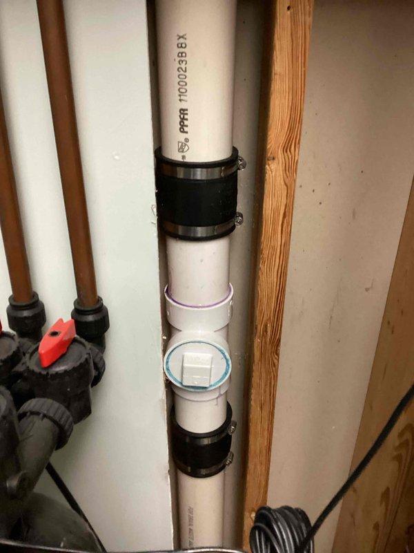 Responded to a service call for toilet drain leak affecting basement laundry room. Diagnosed a cracked 3" clean out fitting at the hub on the main stack, which was leaking when drain was in use. Replaced the damaged section by cutting out the compromised clean out fitting and PVC pipe, then installed new clean out and pipe sections. Verified repair by testing toilet flush, confirming proper function with no leaks.