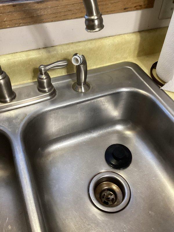 Fixed kitchen sink issues by retrieving knife stuck in drain line and reseating leaking side sprayer (advised customer to contact Moen for warranty replacement parts). Installed new lift and turn drain assembly in hallway tub/shower to address non-functioning drain stopper.