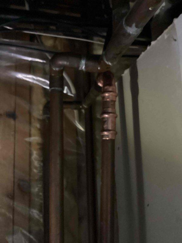 Identified and repaired a pin hole leak on a 3/4" copper supply line located directly above the water softener. Removed the damaged section of copper pipe and 90° fitting, then replaced with new copper pipe and fitting. System tested after repair with water restored and verified proper function with no leaks.