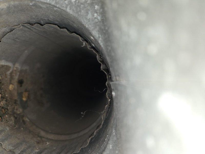 Performed comprehensive duct cleaning service as part of installation package, removing accumulated dust and dust bunnies from the ductwork system. Thoroughly cleaned all vents and documented the condition of ductwork, noting serrated edges and minor debris accumulation in circular metal ducts.