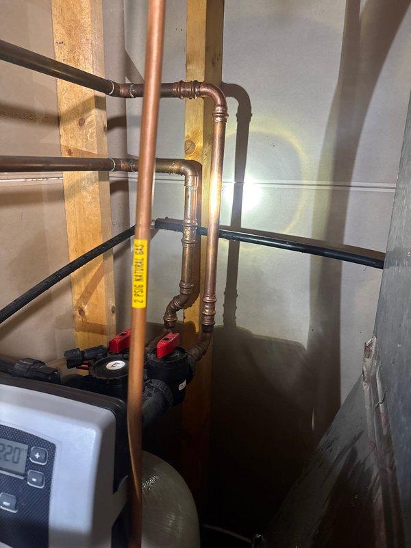 Responded to report of a pinhole leak on a 3/4" copper pipe at the water softener inlet in the basement. Diagnosed the issue as a pinhole leak in the cold water line. Replaced affected section of copper piping, ensuring proper connections and testing for leaks. All plumbing components now functioning correctly with no signs of leakage.