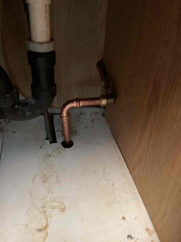 Installed new frost-free outdoor hose bib by disconnecting old exterior faucet, drilling vertically through subfloor into kitchen cabinet, and running 3/4" copper riser pipe through floor and cabinet to exterior. Connected all components with new copper fittings, creating proper water supply line from interior plumbing to new exterior frost-free faucet.