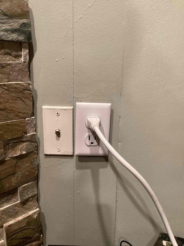 Responded to callback for previously installed outlet near TV/fireplace that was tripping customer's surge protector. Investigation revealed touching wires causing the issue. Removed outlet, verified all connections, applied electrical tape to terminals and conductors to prevent unintended contact, and reinstalled the outlet to restore proper function.
