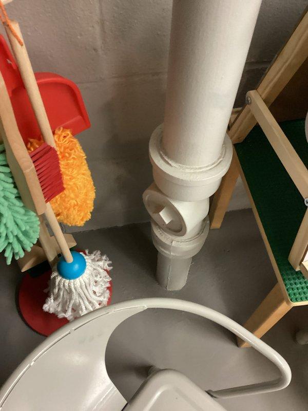 Completed inspection of residential plumbing system, documenting PVC drainage components in utility area and examining water supply configuration with insulated pipes, flow control device, and dual shut-off valves mounted against cinder block wall. System appears functional with some minor insulation wear noted on piping.