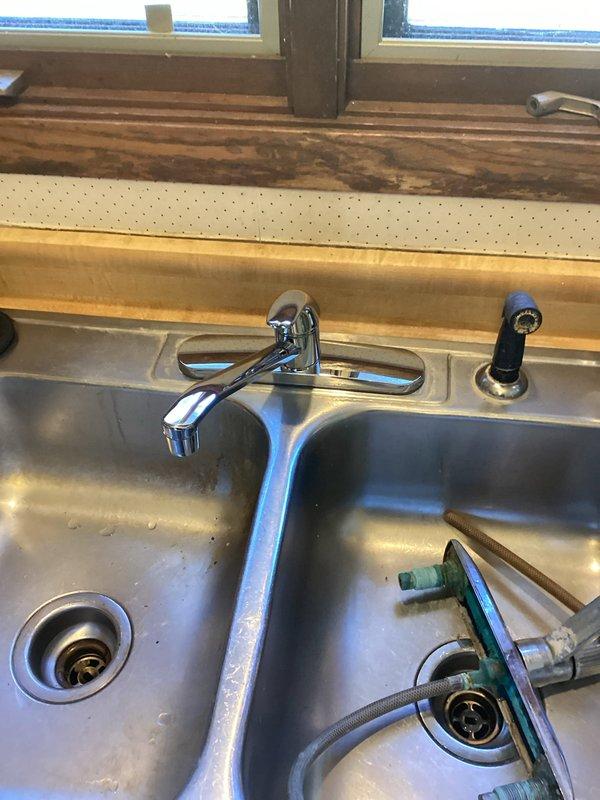 Responded to service call regarding inoperative kitchen sink faucet with no water flow. Diagnosed heavy sediment and calcification buildup in the faucet cartridge causing complete flow restriction. Resolved issue by installing new kitchen faucet and angle stops, then restored water service to home with successful functional testing.