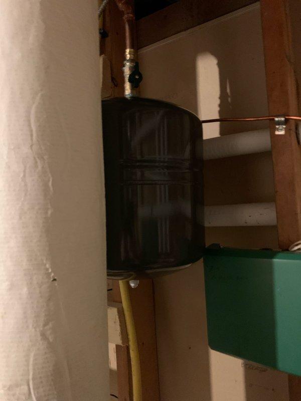 Installed expansion tank in utility area with proper copper pipe connections. System includes black cylindrical tank integrated into existing plumbing network with appropriate valves and fittings. Service completed between 10-12pm as scheduled.