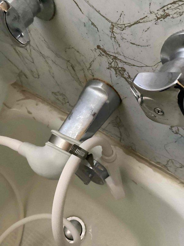 Responded to service call for leak from tub into basement. Diagnosed issue with customer's DIY shower conversion setup - rubber boot over tub spout secured with hose clamp was allowing water to backflow into wall cavity during use. Advised customer that proper shower installation would require bathroom wall reconstruction to accommodate proper shower head plumbing.