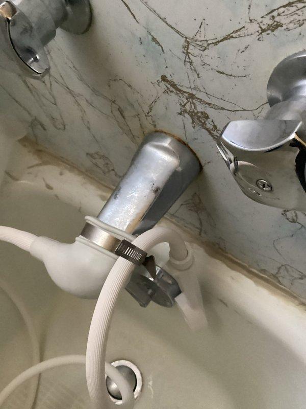 Responded to service call for leak from tub into basement. Diagnosed issue with customer's DIY shower conversion setup - rubber boot over tub spout secured with hose clamp was allowing water to backflow into wall cavity during use. Advised customer that proper shower installation would require bathroom wall reconstruction to accommodate proper shower head plumbing.