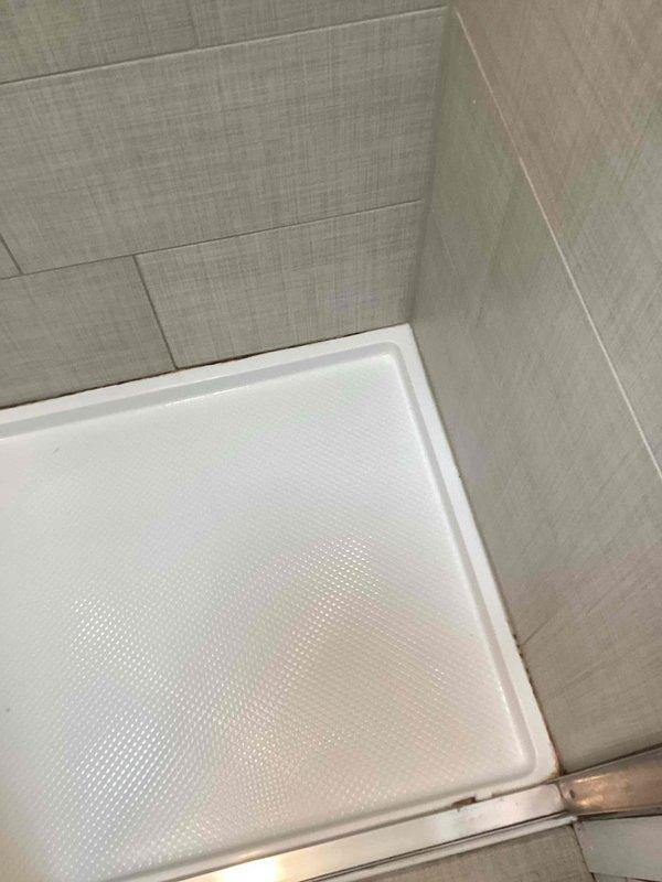 Returned to address callback for shower caulking quality concerns. Removed previously applied fresh caulk from shower surround and re-caulked all seams between the textured acrylic shower pan and surrounding tile walls to ensure proper water-tight seal and improved aesthetic finish.