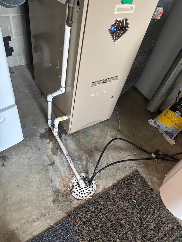 Responded to service call for damaged PVC piping in utility room affecting HVAC condensate drainage system. Upon arrival, identified cracked condensate drain line connected to air handler unit, with visible water damage and moisture staining on concrete floor surrounding equipment base. Repaired damaged condensate drain piping to restore proper drainage function and prevent further water accumulation in the mechanical space.