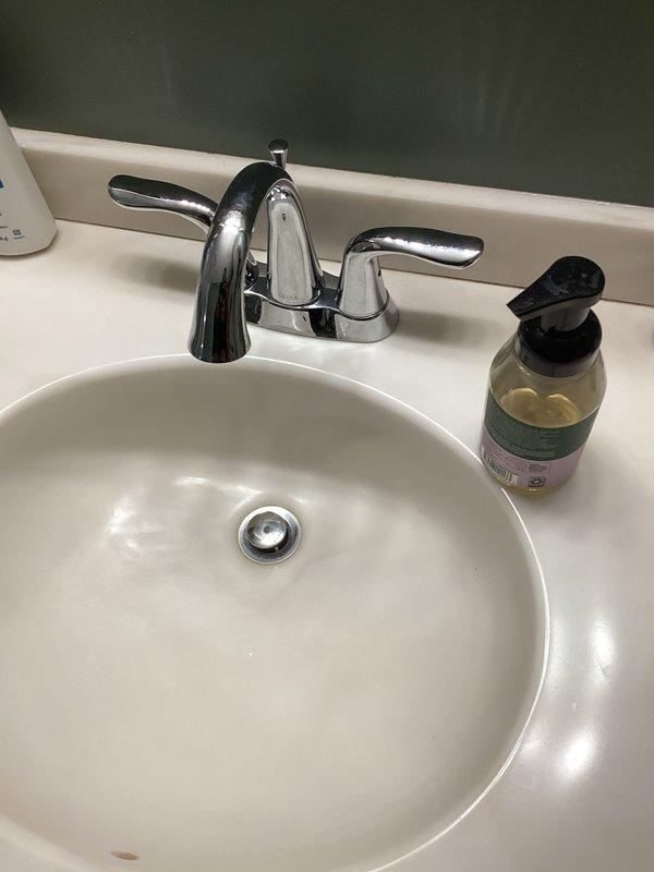 Completed comprehensive home plumbing inspection including evaluation of bathroom fixtures and water supply connections. Inspected bathroom sink with drop-in basin, chrome faucet assembly with dual handles, and angle stop valve with flexible supply line connection, documenting all visible plumbing components and fixture conditions with photographic records.