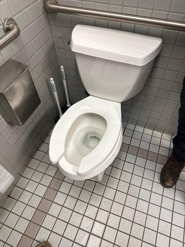 Responded to clogged toilet in warehouse bathroom. Upon inspection, identified that the flapper chain was too long, preventing the flapper from properly sealing against the flush valve seat. Adjusted and shortened the chain to correct length, restoring proper flush cycle operation and resolving the clog issue.