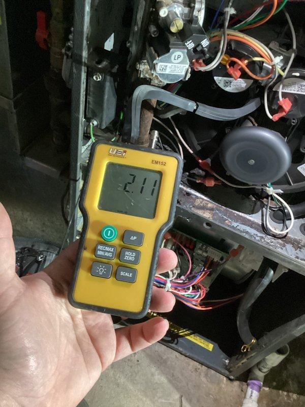 Responded to no heat call back on furnace system. Upon inspection, discovered water accumulation in pressure switch hose causing system failure. Replaced faulty pressure switch, verified proper operation with diagnostic testing showing -2.11" W.C. pressure reading, and installed rain gutter to prevent future water intrusion issues.