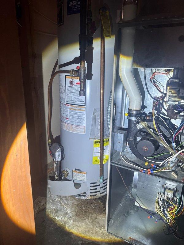 Responded to callback regarding lack of hot water following pressure valve replacement. Upon arrival, restored hot water functionality to the system. Identified improperly secured condensation line that was not glued at connection point, causing water discharge onto basement floor. Applied proper PVC cement to condensation line connections to ensure watertight seal and prevent future leakage. Documented existing water staining on concrete floor from condensation line issue.