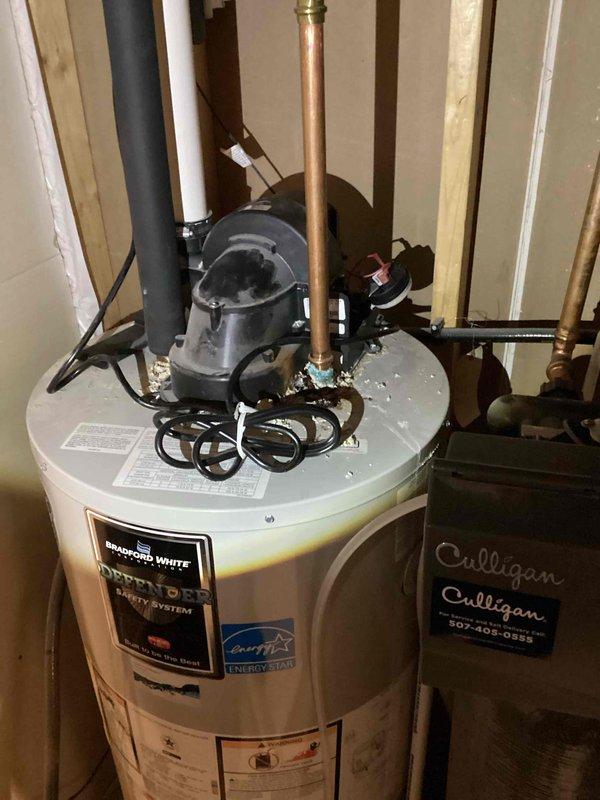 Responded to service call for gas-fired tanked water heater that would not remain lit and was continuously refiring. Upon inspection, discovered severely corroded inlet and outlet connections with active leaking at both connection points. Corrosion extended to internal water heater adaptors, rendering the unit unrepairable. Additionally, the gas control valve displayed a diagnostic fault code indicating pressure switch malfunction—either stuck open or closed position. Attempted to reset the pressure switch, but unit continued to experience ignition failure and would not maintain flame. Visual inspection revealed significant rust staining and mineral deposits throughout the tank exterior, with pronounced copper oxidation (green-blue corrosion) at pipe connections indicating long-term water intrusion. The 6-year-old Bradford White power vent unit was determined to be a total loss due to multiple system failures including compromised water connections, internal leak damage, and gas contro