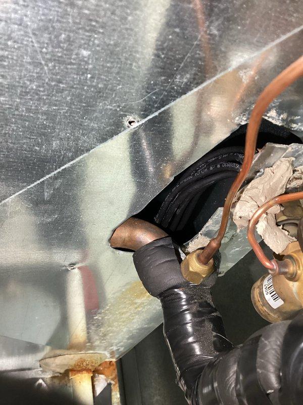 Responded to furnace condensate leak issue. Upon arrival, identified water leaking from condensate line due to missing seal around suction line penetration through cabinet. Sealed the opening around suction line to prevent further condensate leakage. System inspection revealed frost buildup on evaporator coil assembly and associated refrigerant lines, indicating proper cooling operation. Completed repairs and verified no additional leaks present.